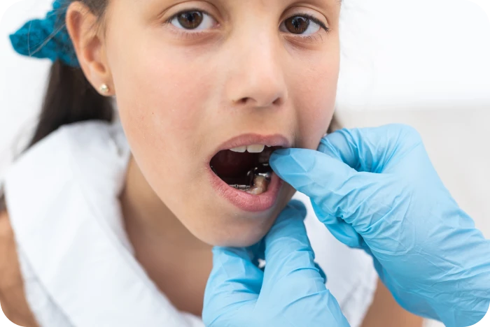 Orthodontiste activant le disjoncteur orthodontique d’une jeune patiente