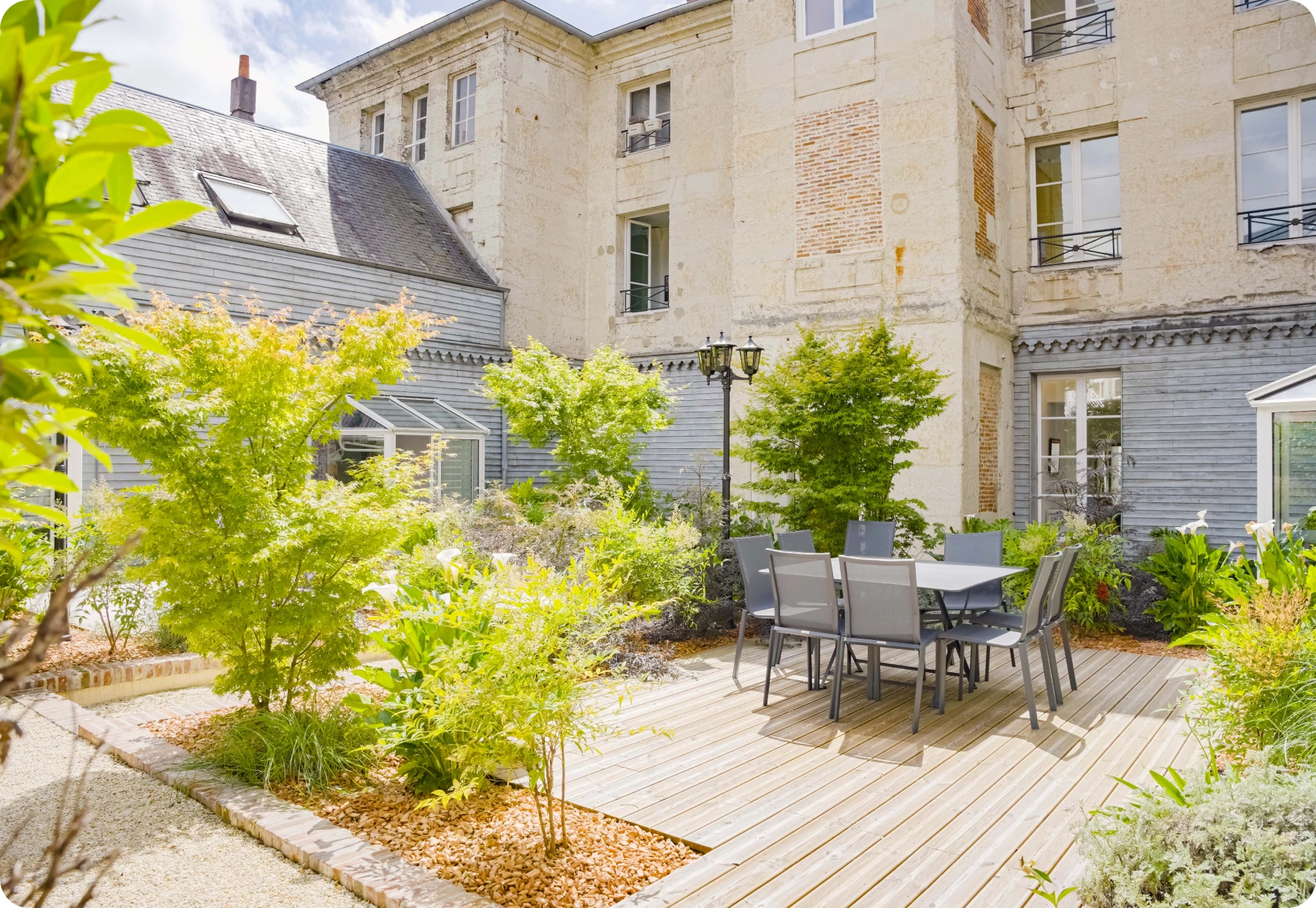Cour extérieure avec terrasse, table et végétation