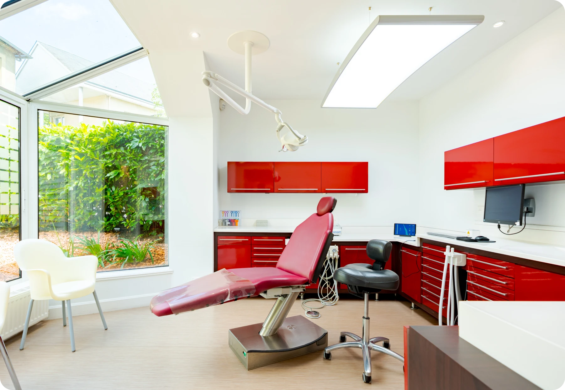 Salle de soins du cabinet des Drs Davy & Alam avec mobilier rouge
