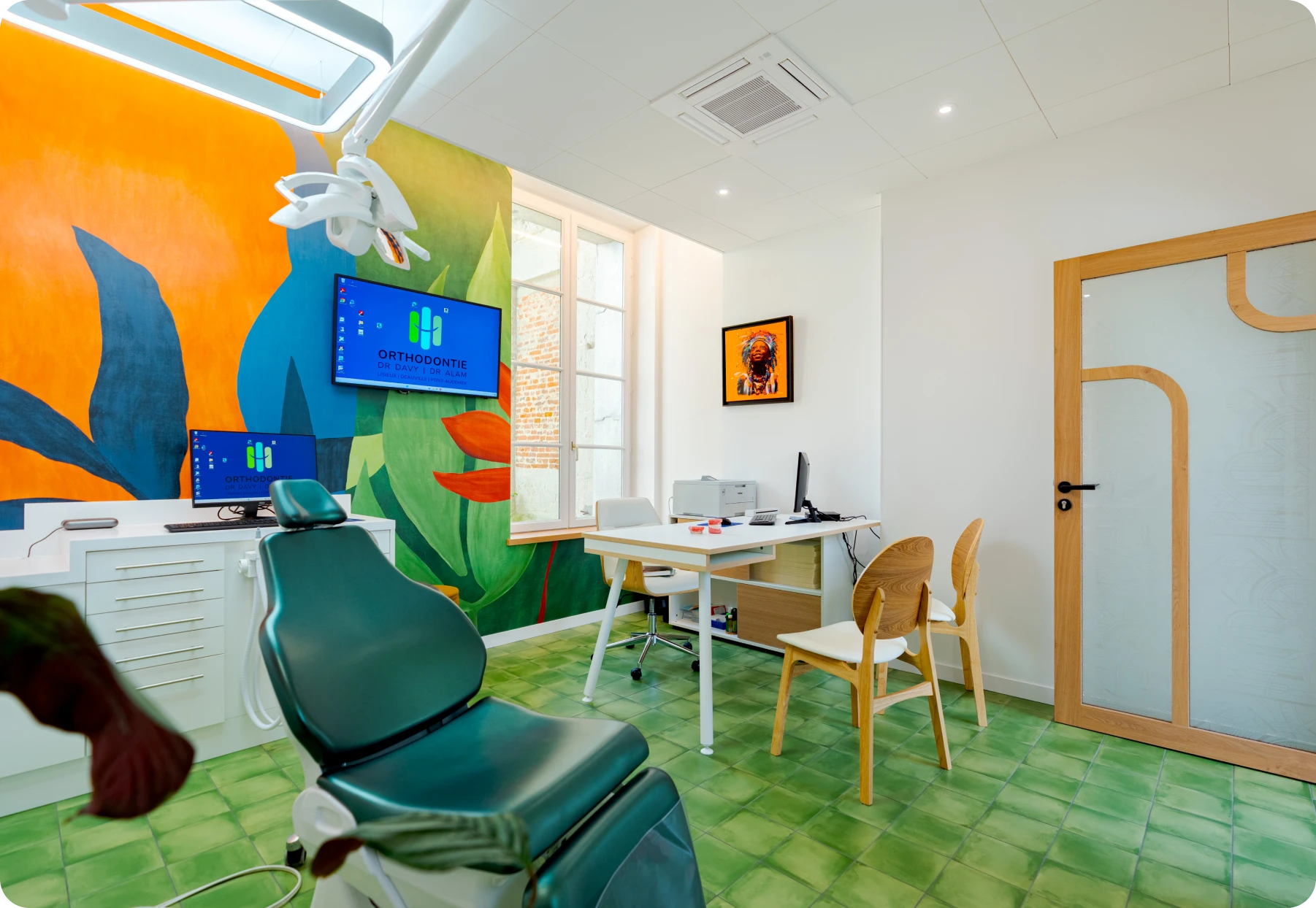 Salle de soins avec fresque tropicale colorée et fauteuil de traitement vert