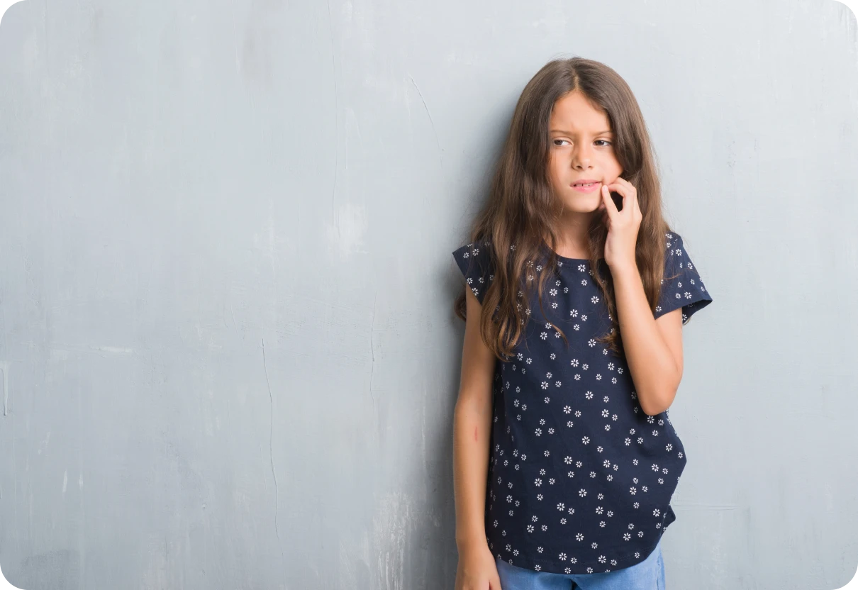 Jeune fille inquiète suite à un problème avec son appareil orthodontique