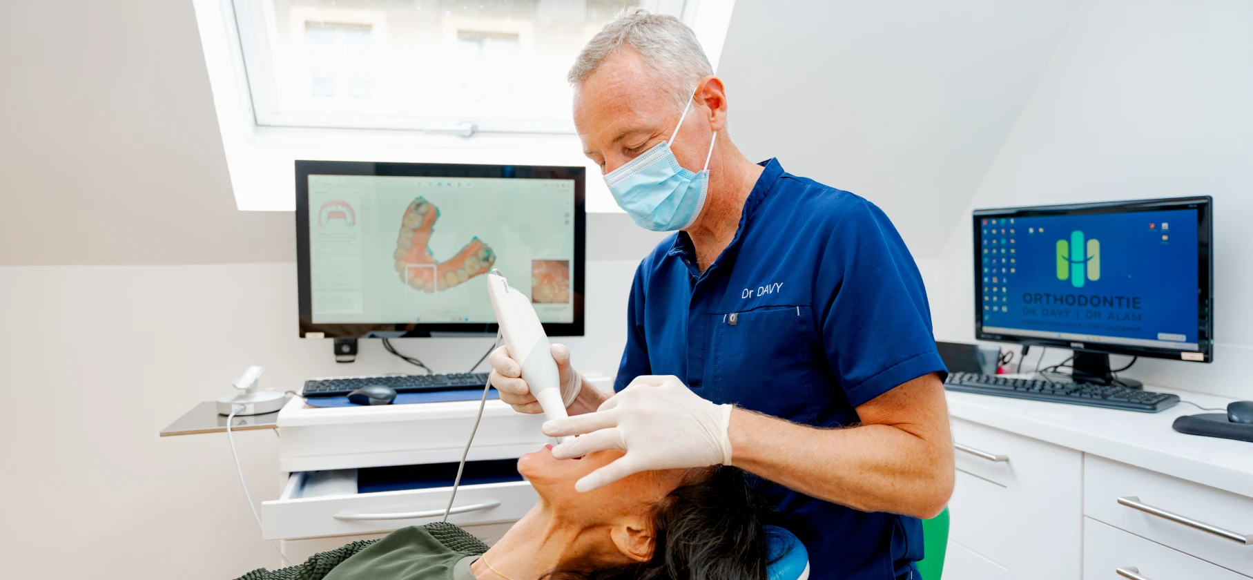 Dr Jean-Luc Davy réalisant une empreinte optique numérique avec caméra intra-buccale sur une patiente