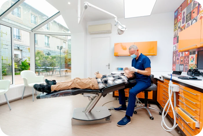 Le Dr Davy examinant un patient dans son cabinet d'orthodontie