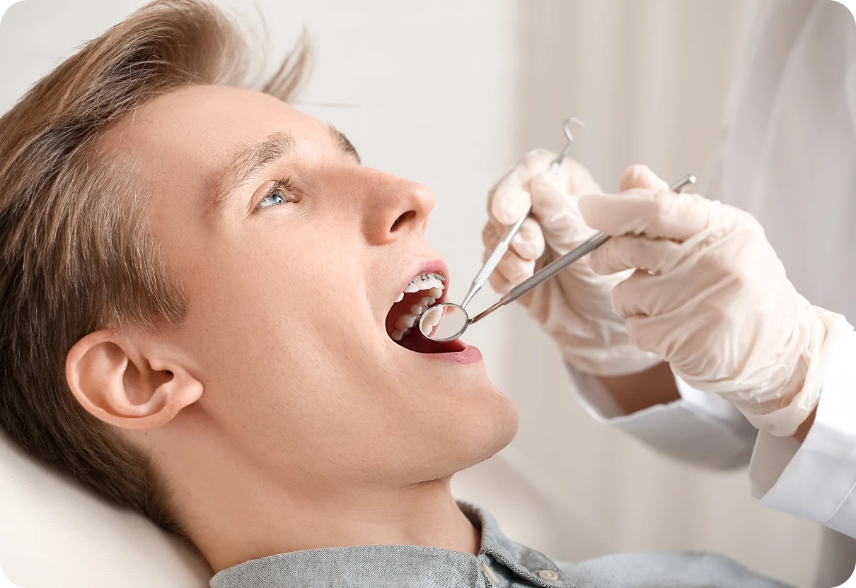 Orthodontiste examinant l'appareil dentaire d'un patient au cabinet
